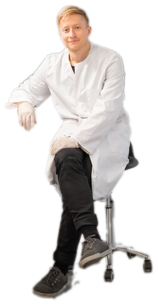 Johann Bauerfeind in a lab coat on a lab stool